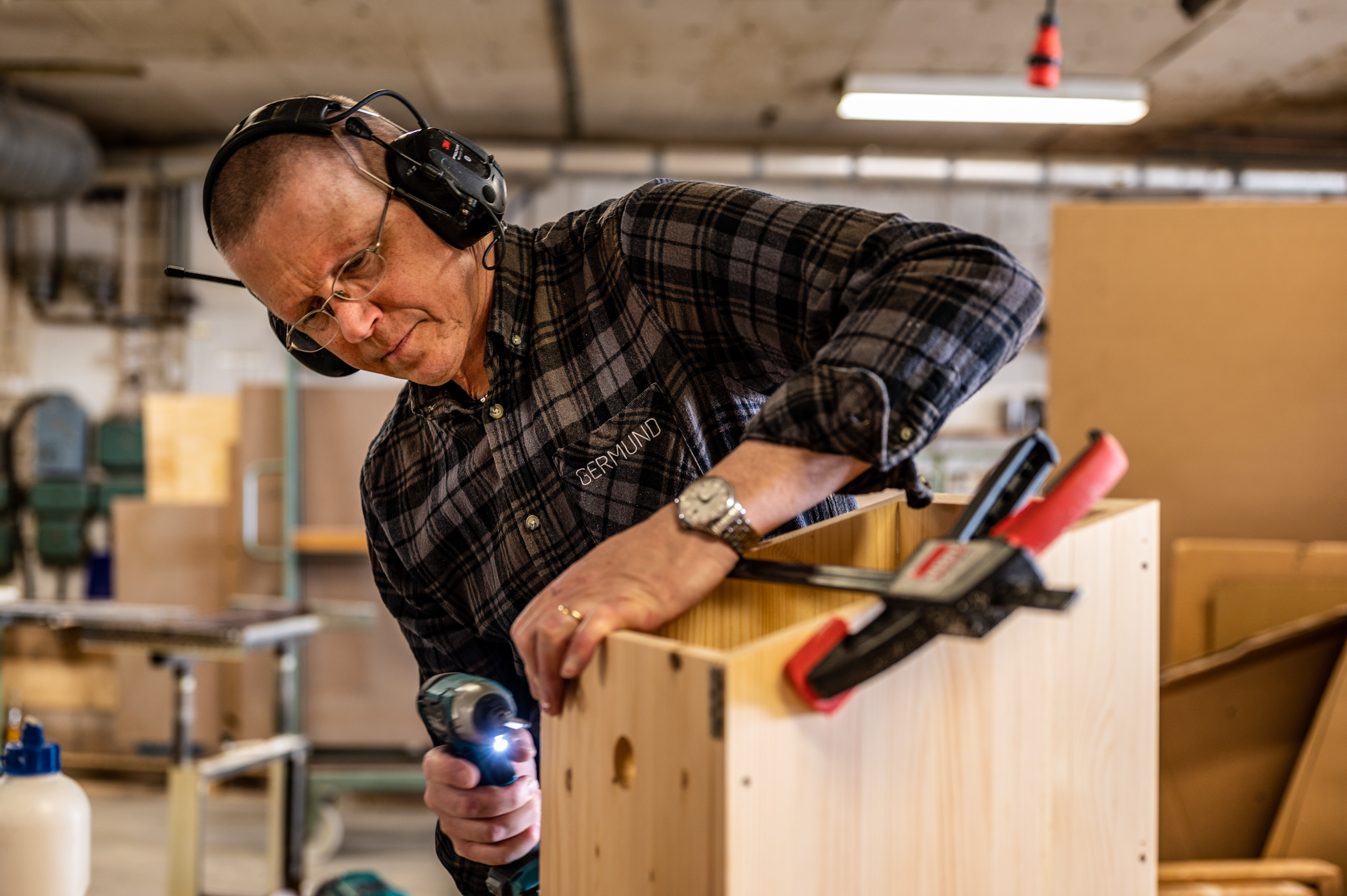 Germund jobber i snickeriet med skruvdragare och tving. Tillverkar fågelholkar till Treehotels 8:e rum